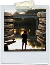 picture of a boy next to canoes